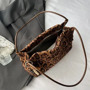 Leopard print faux suede tote bag with brown straps on a casual lifestyle background