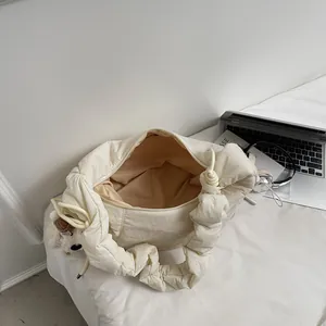 Minimalist creamy white pleated cloud bag with a fluffy puppy pendant and spacious interior
