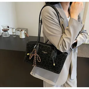 Sac fourre-tout à imprimé léopard avec bandoulière porté par un mannequin