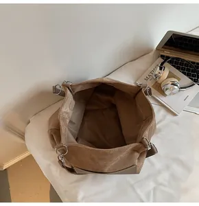 Detailed top view of large brown suede tote bag showing spacious interior and metal rings