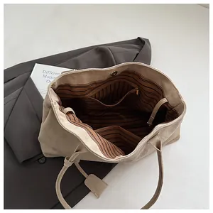 Interior view of large beige tote bag with striped lining and magnetic closure