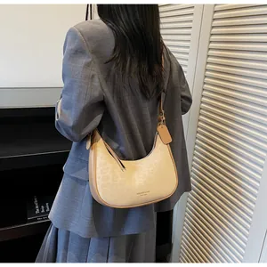 Close-up of leopard print hobo bag in cream leather shown on model's shoulder
