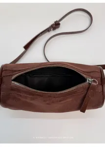 Dettaglio dell'apertura con zip e della fodera interna nera della borsa a cilindro marrone