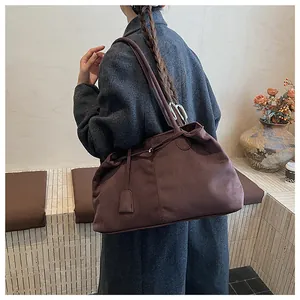 Detail of a large brown suede tote bag with slim shoulder straps for autumn winter