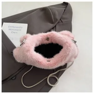 Detail of pink faux fur bag featuring silver chain strap and magnetic metal closure