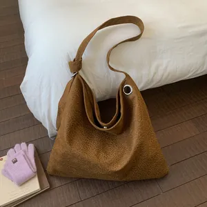 Detail of hobo tote bag featuring leopard print suede texture and metal ring buckle