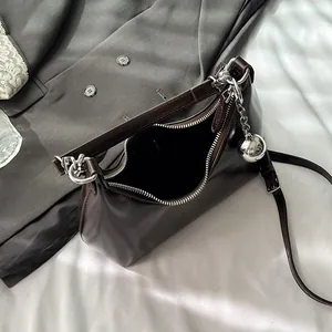 Dark brown leather hobo bag with a silver sphere charm and adjustable shoulder strap