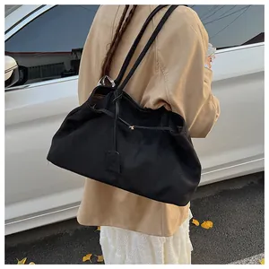 Close-up of black matte tote bag with drawstring detail and slim leather straps
