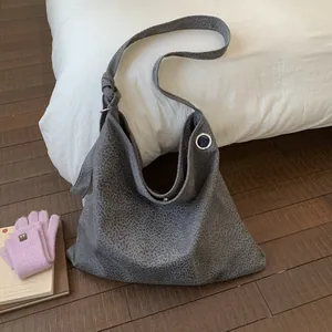 Detail of grey leopard print tote bag with wide shoulder strap and metal ring hardware