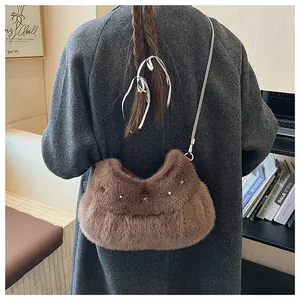 Detail of plush brown shoulder bag with silver star rivets and metal chain strap
