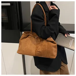 Detail shot of large brown suede tote bag with metal ring buckle and side tag accessory