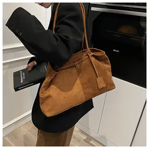 Detailed view of a tan matte tote bag on a model featuring a textured suede finish