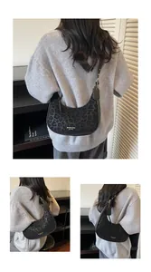 Detail of leopard print crescent hobo bag featuring golden hardware and logo branding