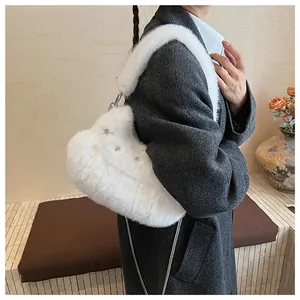 Detail of white faux fur shoulder bag with plush strap and elegant metal chain elements