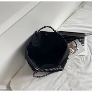 Detail of black tote bag interior with magnetic clasp and polka dot rope handle