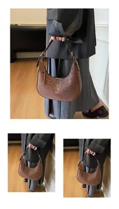 Macro detail of dark brown leopard print hobo bag with gold zipper and brand stamp