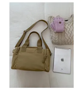 Detailed view of khaki nylon travel tote with reinforced handles and adjustable strap
