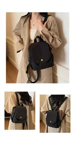 Detail of minimalist black canvas backpack with a contrasting yellow snap button and side pocket