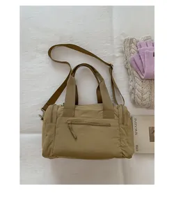 Overhead view of khaki nylon travel bag with zippers and cozy winter accessories