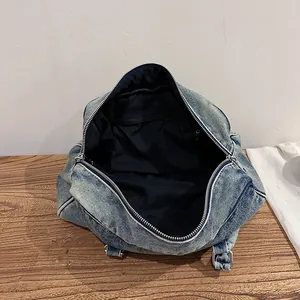 Light blue washed denim tote bag showing interior lining and silver zipper details