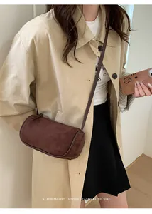 Borsa a tracolla cilindrica marrone retrò in pelle scamosciata opaca su modella