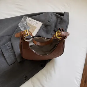 Brown matte leather half-moon shoulder bag with adjustable straps and gold-tone hardware