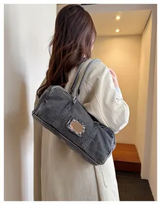 Detailed side view of washed denim tote bag with metal logo and frayed edge accents