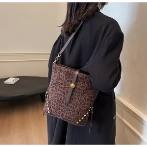 Dettaglio della borsa a secchiello leopardata con rivetti dorati e trama in pelle