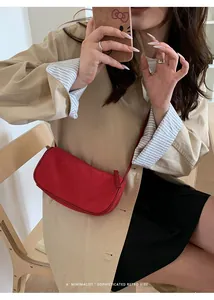 Dettaglio della borsa baguette in pelle scamosciata rossa con cerniera in metallo