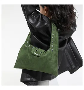 Dettaglio della borsa a spalla in camoscio verde scuro con occhielli metallici argento