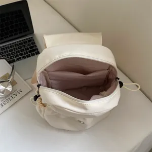 Minimalist cream canvas backpack with flap opening and internal pockets for students