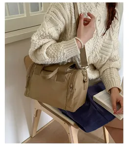Close-up of khaki travel duffle bag with dual zippers and adjustable shoulder strap