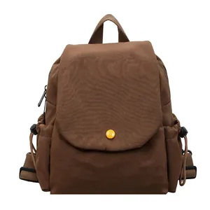 Brown canvas laptop backpack with front yellow button and drawstring side pockets