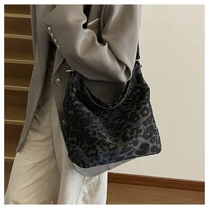 Detail of large leopard print bucket bag styled with a gray blazer for a commute look