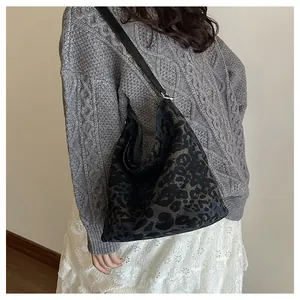 Deep-toned leopard print hobo bucket bag styled with a gray cable knit sweater