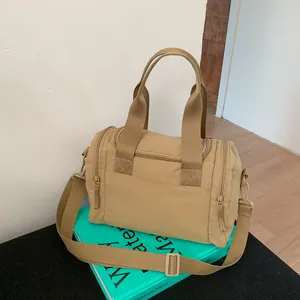 Macro view of khaki nylon travel bag showing durable handles and adjustable shoulder strap