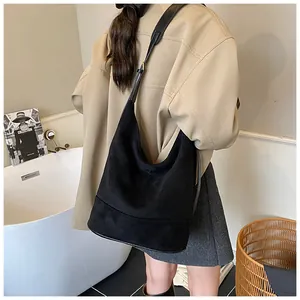 Detail of adjustable strap and matte suede texture on a black hobo shoulder bag