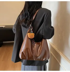 Deep brown PU leather shoulder bag with plush bear charm and plaid scarf detail