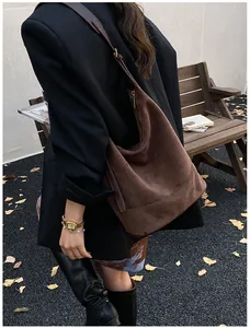 Close-up of a large dark brown suede hobo bag with vintage gold zipper and shoulder strap