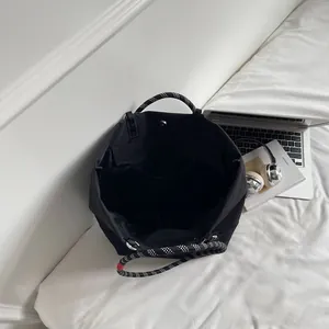Black large capacity tote bag with woven handles and spacious interior compartments