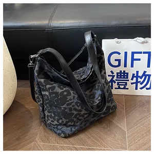 Detailed close-up of dark leopard print tote bag with black leather straps and silver buckle