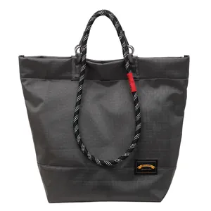 Minimalist large capacity dark grey tote bag with stylish braided rope handles on white background