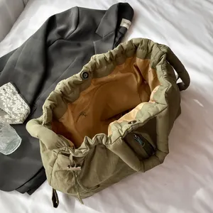 Quilted nylon tote bag in olive green with yellow lining and large storage capacity