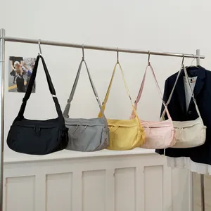 Minimalist nylon crescent crossbody bags in five colors on a display rack