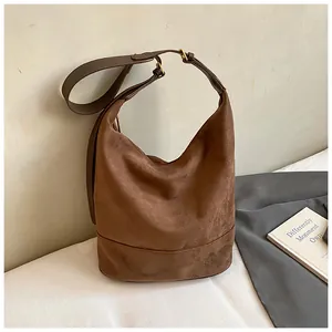 Macro detail of dark brown suede hobo bag with vintage matte texture and golden hardware