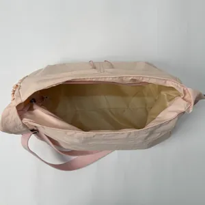 Pink pleated nylon crossbody bag with interior pocket and adjustable strap