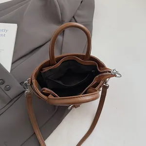Brown leather crossbody bag with spacious interior compartment and dual handles