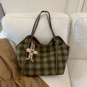 Détail du sac cabas en tweed à carreaux vert et marron avec un joli porte-clés lapin