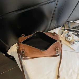 Brown faux suede Boston bowling bag with large capacity for women on white bedding