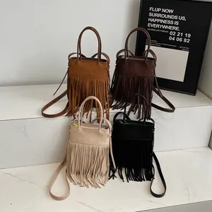 Sacs seaux rétro à franges en quatre couleurs sur des marches de marbre en studio